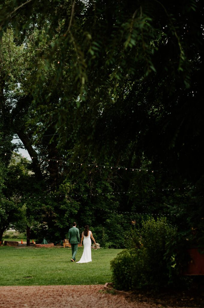 Bride and groom walking hand in hand through a garden after their ceremony, showcasing documentary wedding photography for natural wedding moments.