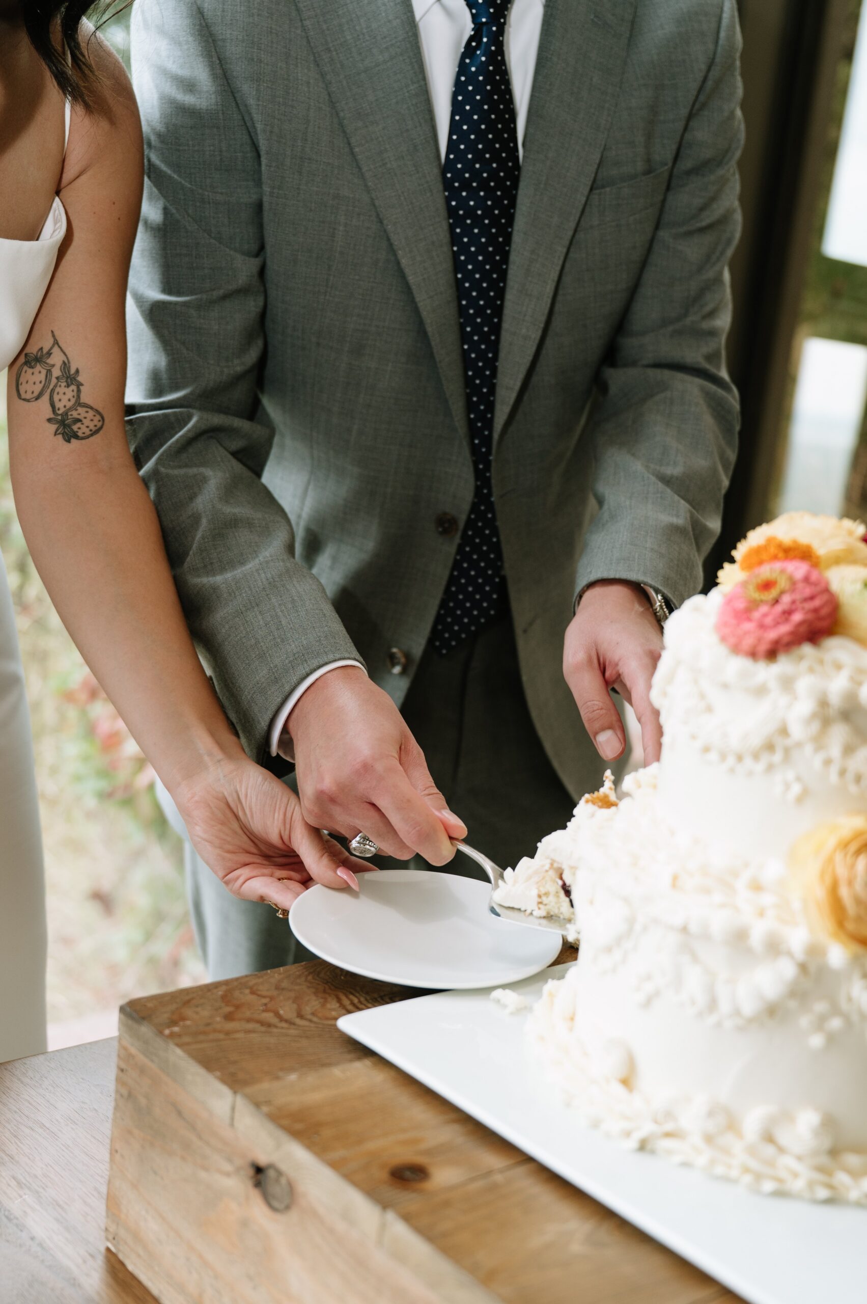 Close-up of the couple serving cake during a reception, a cozy moment that reflects the best time of year to get married in Colorado for intimate celebrations.