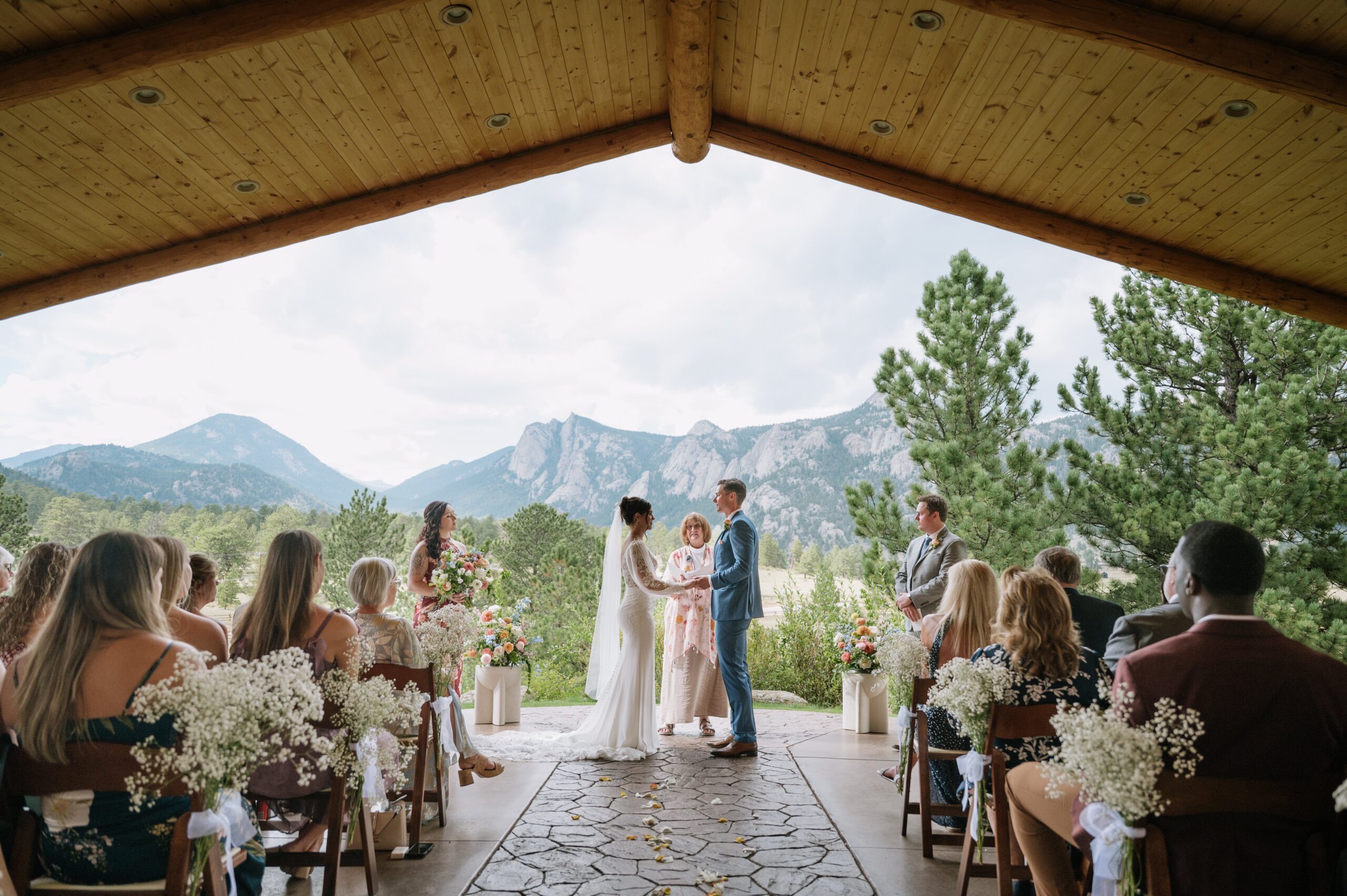 Outdoor wedding ceremony framed by mountains and pine trees, perfectly illustrating the best time of year to get married in Colorado for breathtaking views and mild weather.