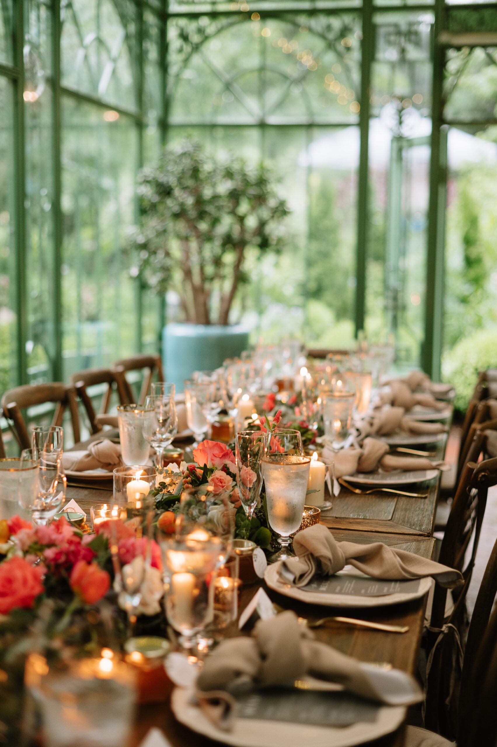 Close-up of romantic reception styling from Denver Botanic Gardens wedding photos, with glowing candles, floral arrangements, and elegant place settings.