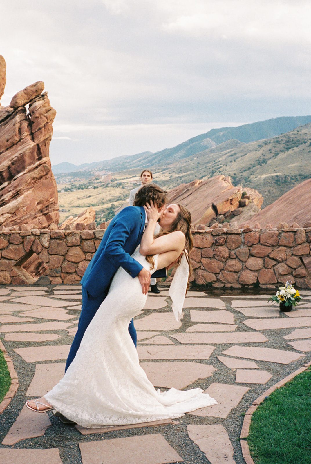 Couple sharing their first kiss surrounded by red rocks at an intimate wedding venue in Colorado