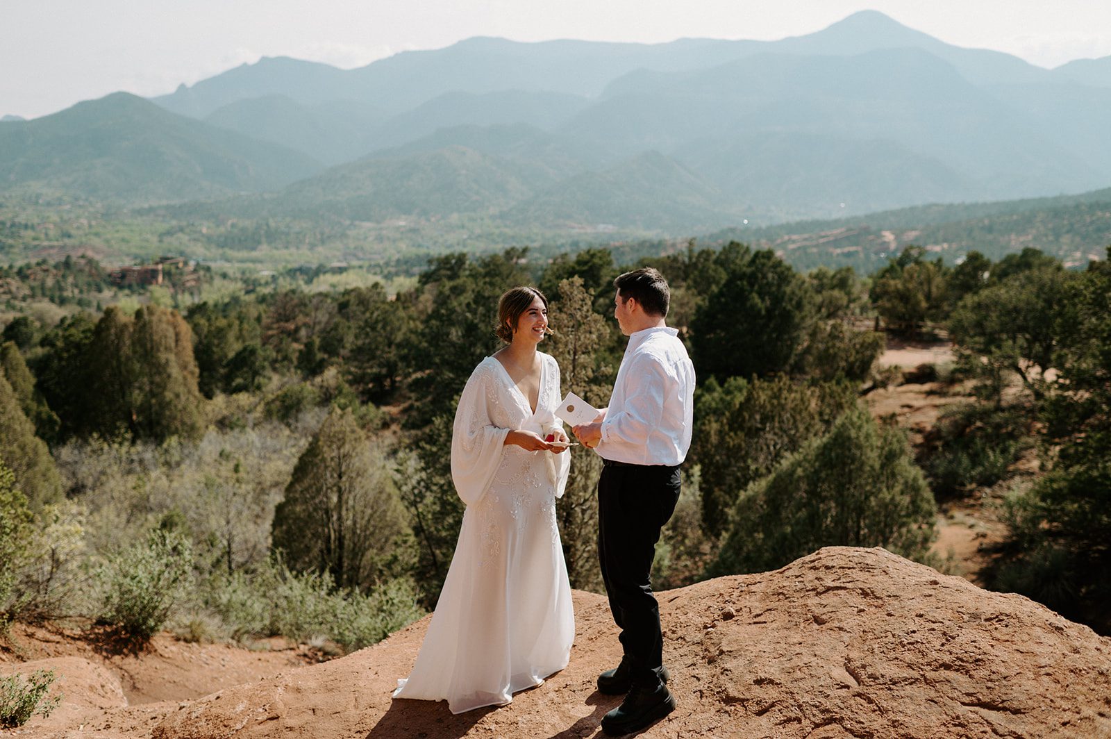 Couple exchanging vows on a scenic overlook during an intimate ceremony at a small outdoor wedding venue in Colorado. 