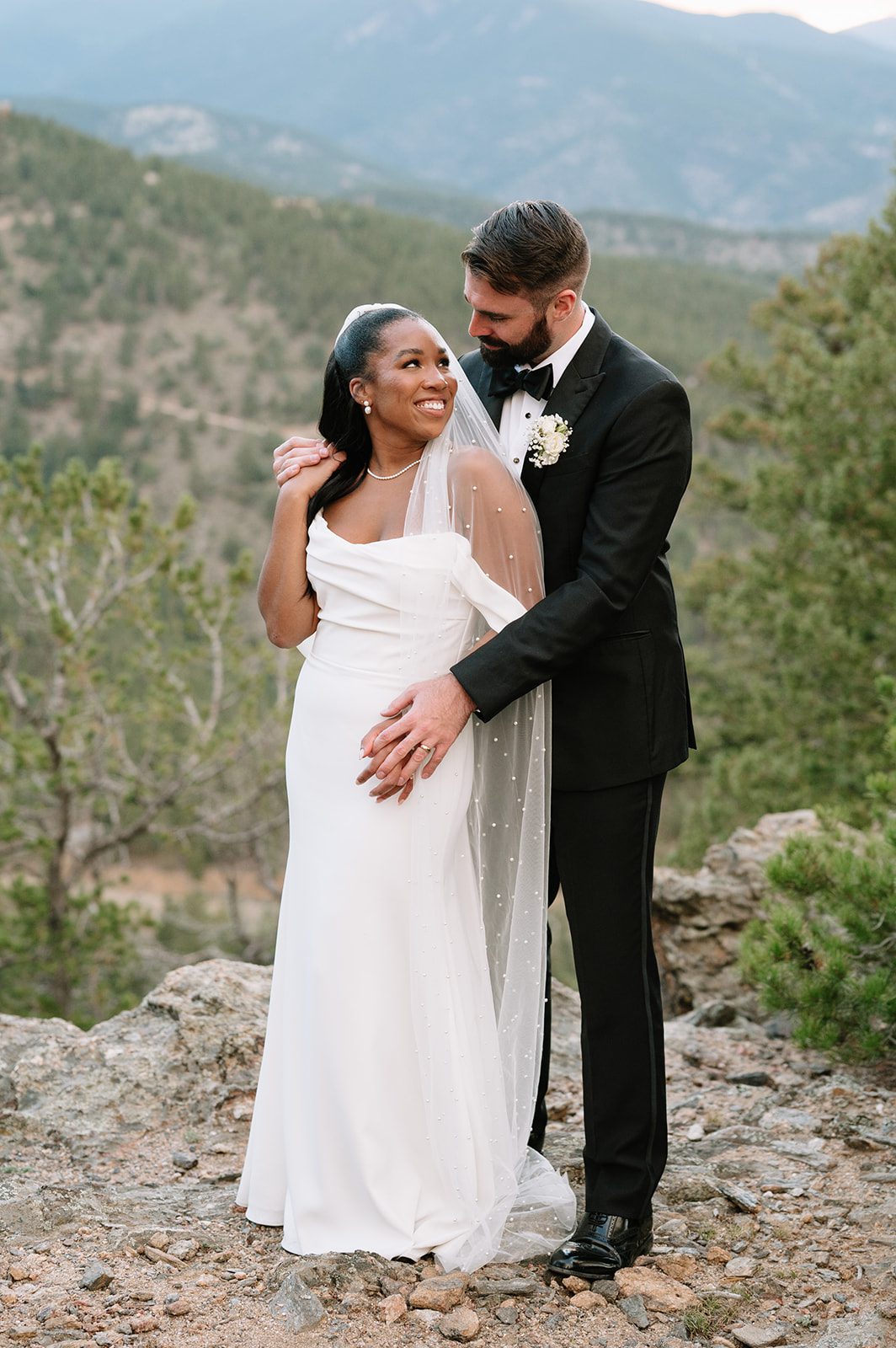 groom embracing his bride from behind during their sunset north star gatherings photo