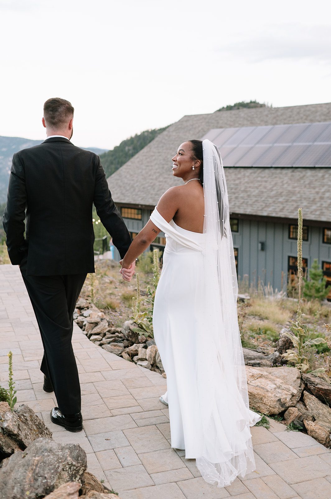 bride smiling at he rgroom while they're walkign towards their north star gatherings wedding reception area