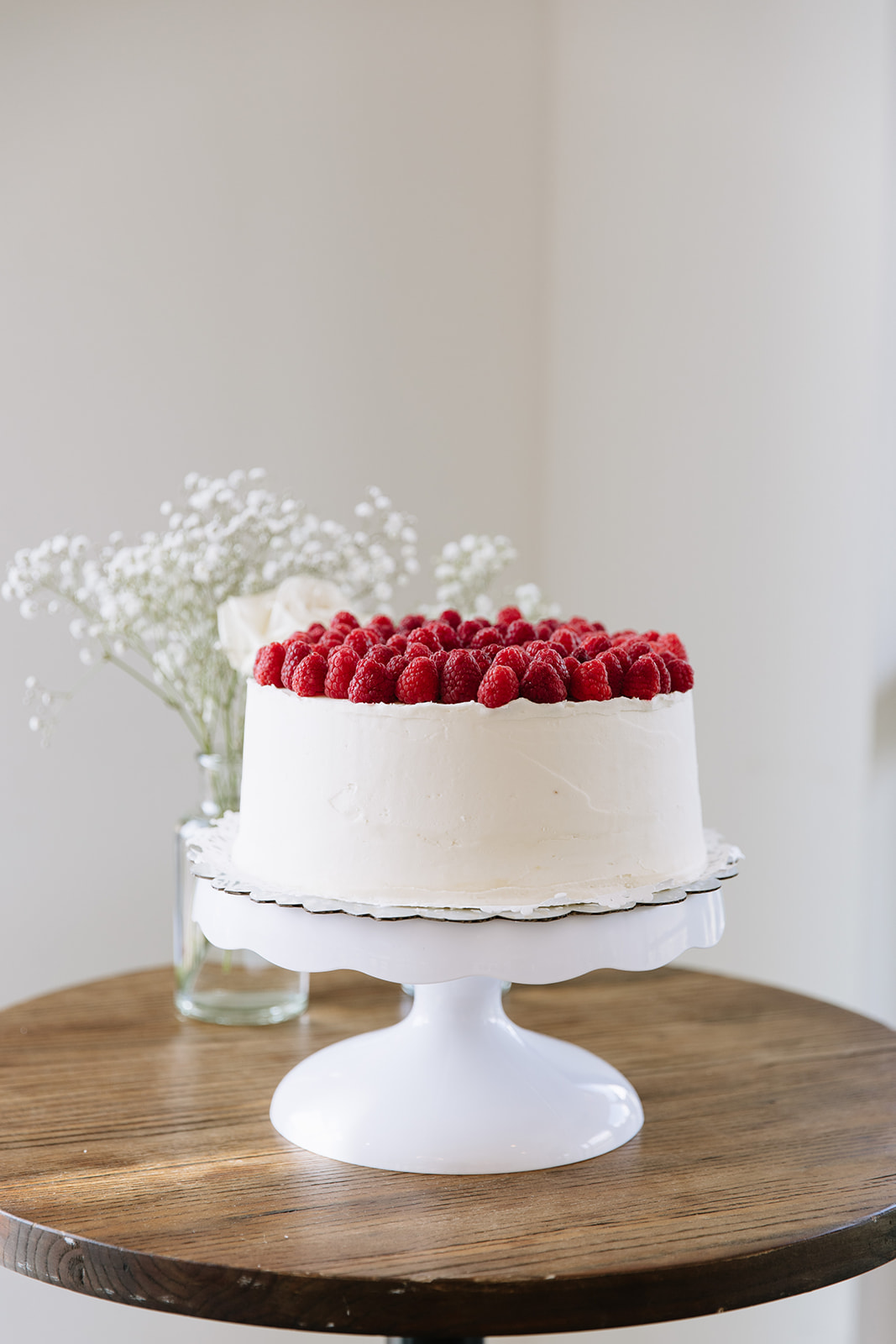white one tier wedding cake with raspberries on top on display at a north star gatherings wedding