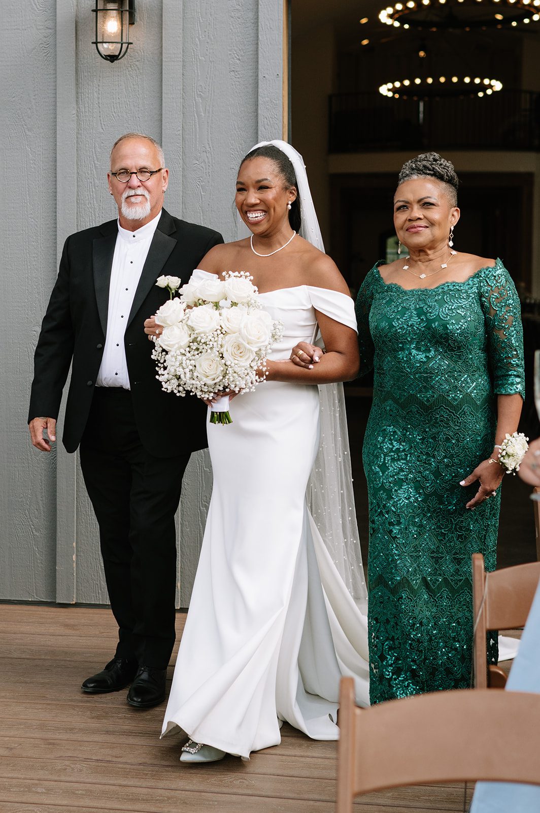 bride walking down the aisle with her mother and father during her wedding at north star gatherings idaho springs co