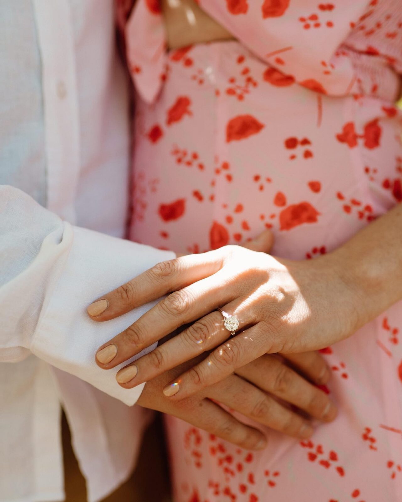 closeup of a couple's hand during their engagement session, showing an engagement ring, and what colors to wear for engagement photos