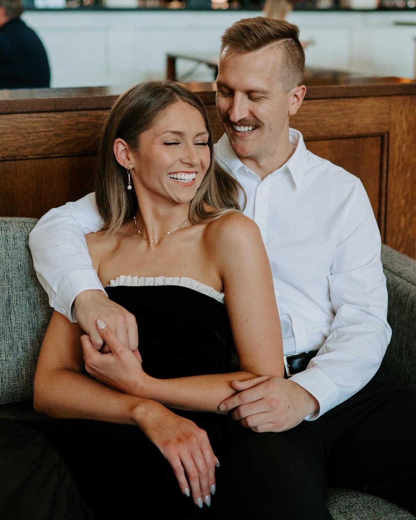 portrait of a couple embracing and laughing, showing the impact engagement photo outfits have on the overall feel of the session