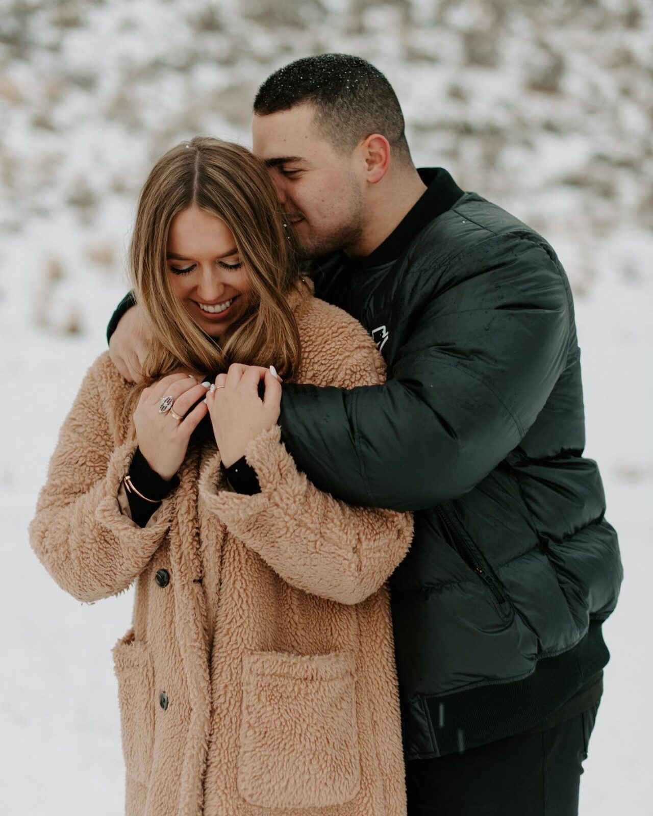 portrait of a couple embracing during their engagement photos, showing engagement photo outfit ideas for winter in colorado